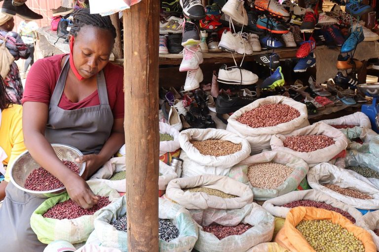 Market merchant sorting goods at her stall in a busy market
